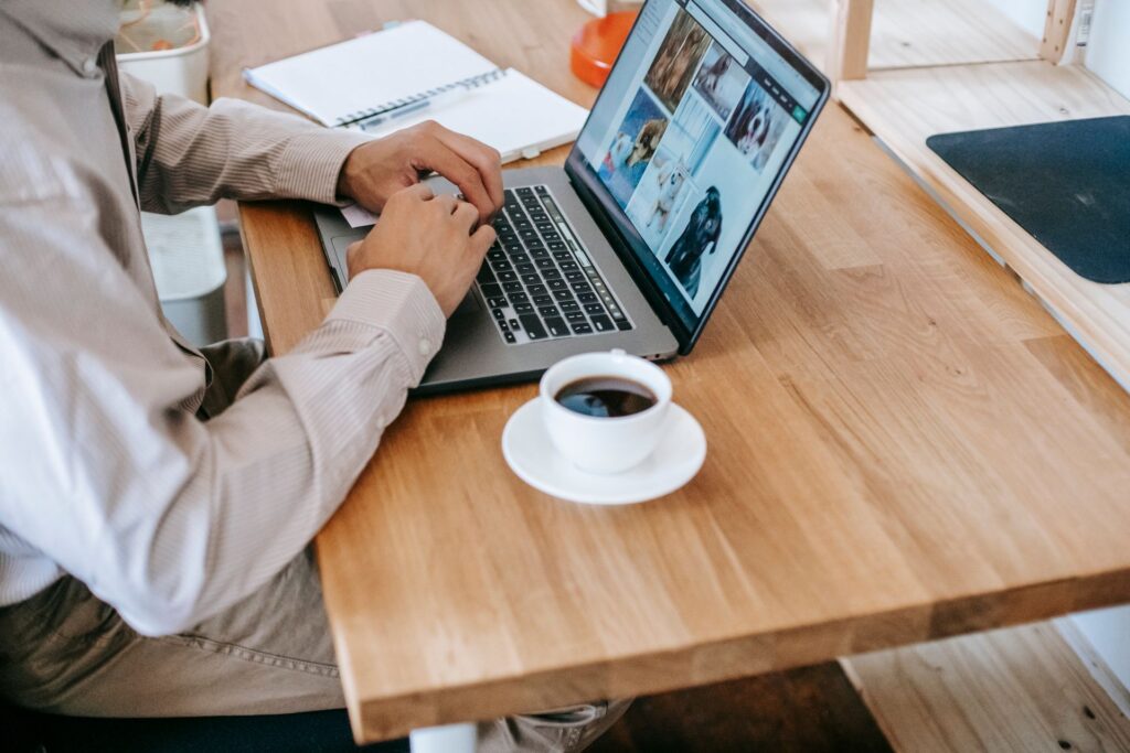 A person working on a laptop while enjoying a coffee